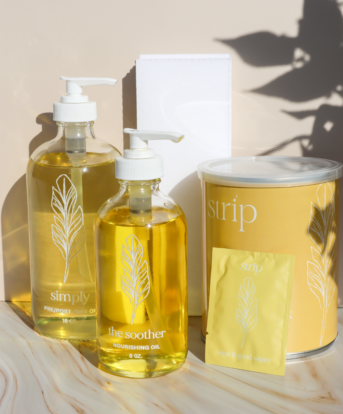 Just The Strip professional waxing supplies with Pre and Post Wax Oil pump bottles, a soft strip wax can, and a Wipe It Good wipe