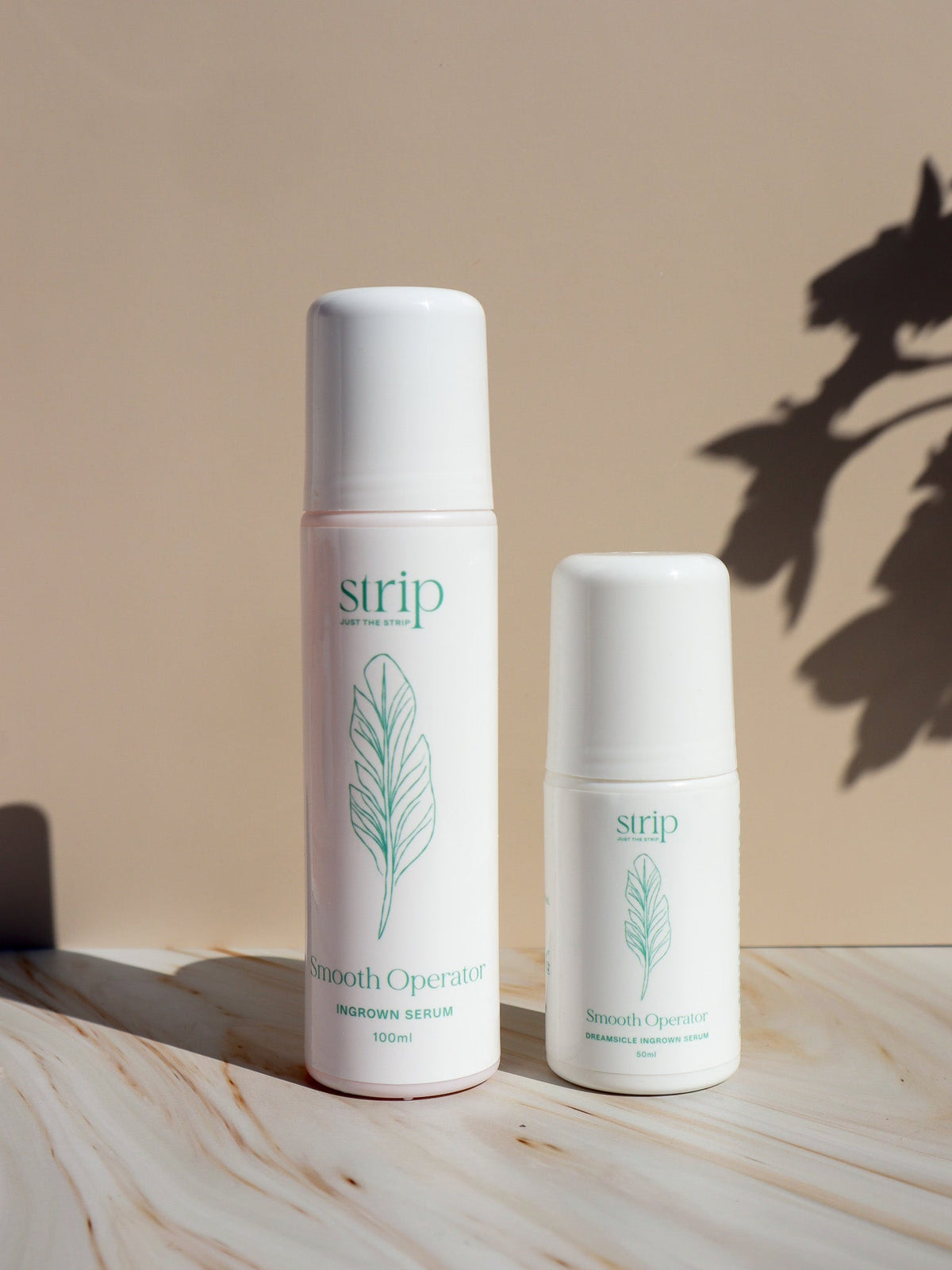 Two Smooth Operator Ingrown Hair Serum bottles from Just The Strip on a marble surface