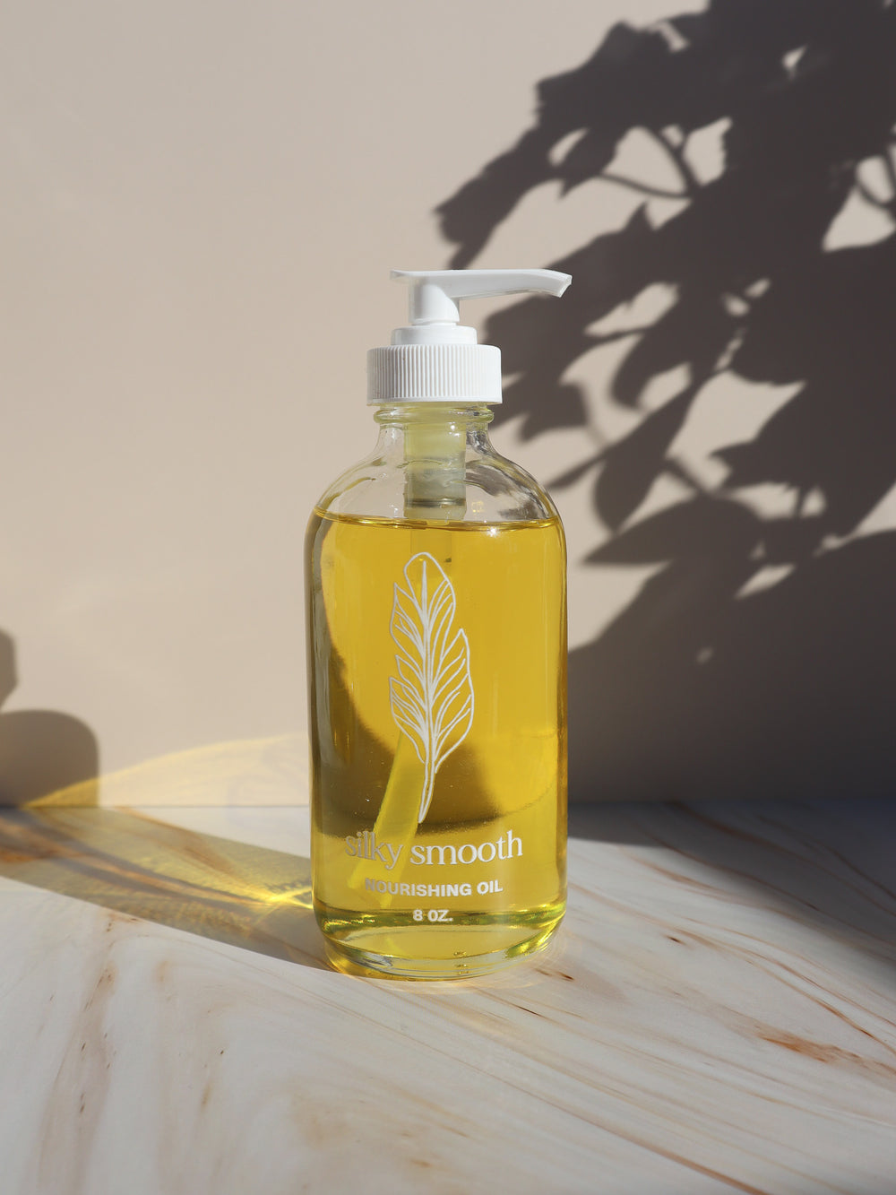 Silky Smooth sandalwood Nourishing Oil in an 8 oz glass pump bottle